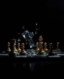 A captivating high-contrast, low-key image showcases a chessboard with pieces frozen mid-air in a moment of chaotic destructi