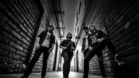 Explore a classic black and white photograph capturing rebellious teens in a grungy city alley from a dramatic low angle pers