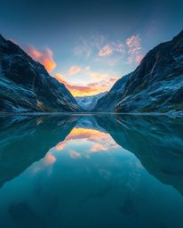 Precise architectural color photography of a glassy fjord reflecting a sunset. This image features sharp lines, detailed stru