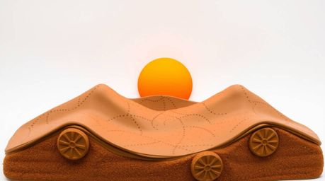 A captivating clay sculpture portrays a breathtaking sunset over majestic golden desert dunes.  The artwork masterfully utili