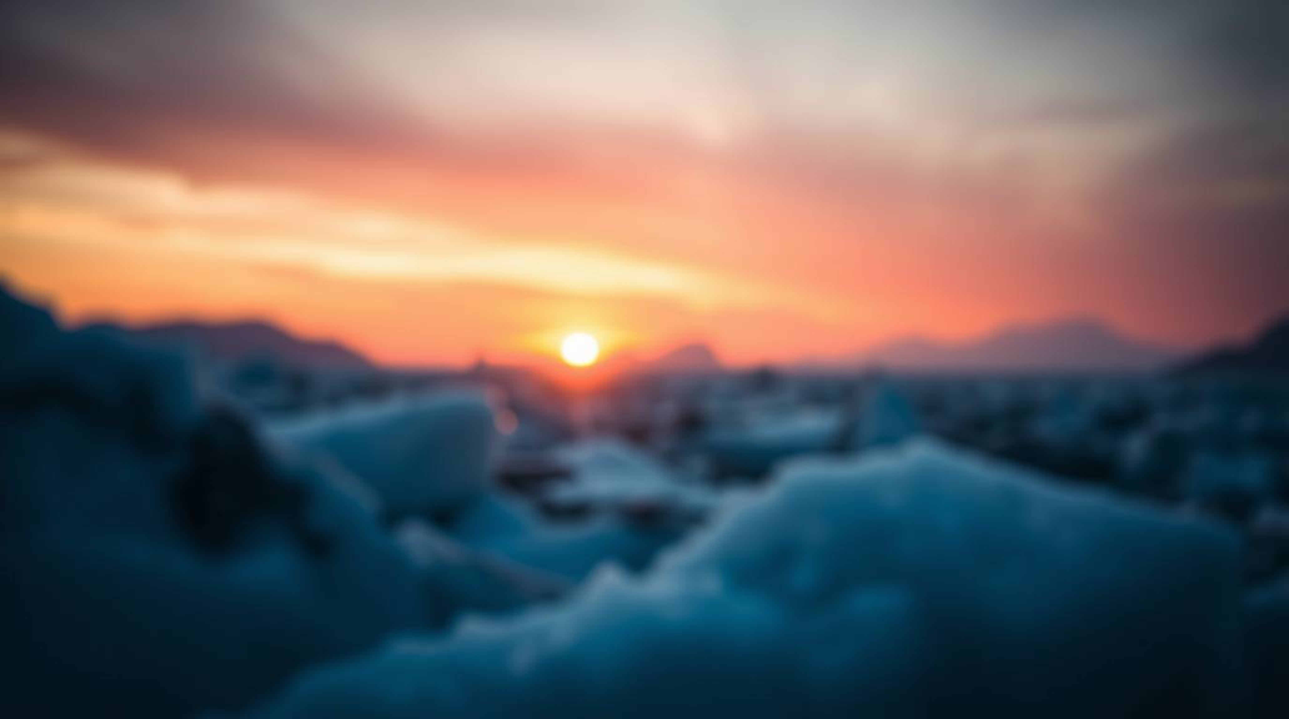 Capture the breathtaking beauty of a sunset over icy glaciers in the polar region. This photograph showcases a mesmerizing bl