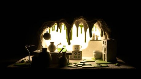 This artwork depicts a slime-covered science lab brought to life in sculptural clay. Silhouetted against backlighting, the pi