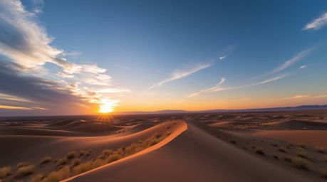 Experience the breathtaking beauty of a high-angle sunset over golden desert dunes. This stunning photograph captures the coo