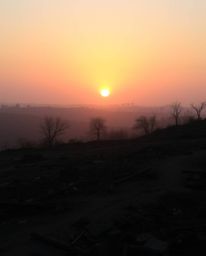 Capture the ethereal beauty of a sunrise over a war-torn landscape. This image showcases gentle, soft, iridescent light with 