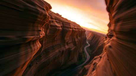 A stunning 16:9 photographic print showcasing a high-angle perspective of a rocky canyon bathed in warm sunset hues.  The lon