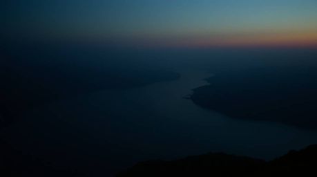 A captivating image of a river delta bathed in the warm glow of twilight.  The moody, low-contrast style evokes a dramatic ci