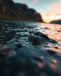 An extreme macro close-up photograph of a glassy fjord reflecting a sunset. This image highlights a stunning interplay of war