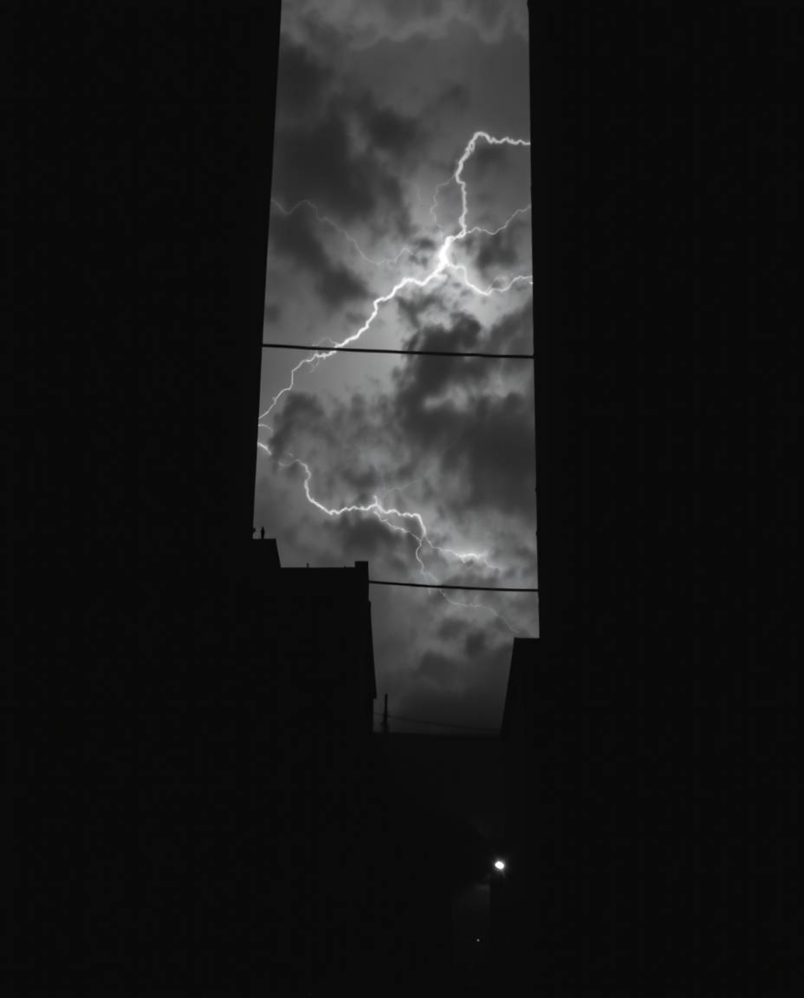 A dramatic black and white photograph capturing the intensity of eyes watching from the shadows of an alley during a stormy n