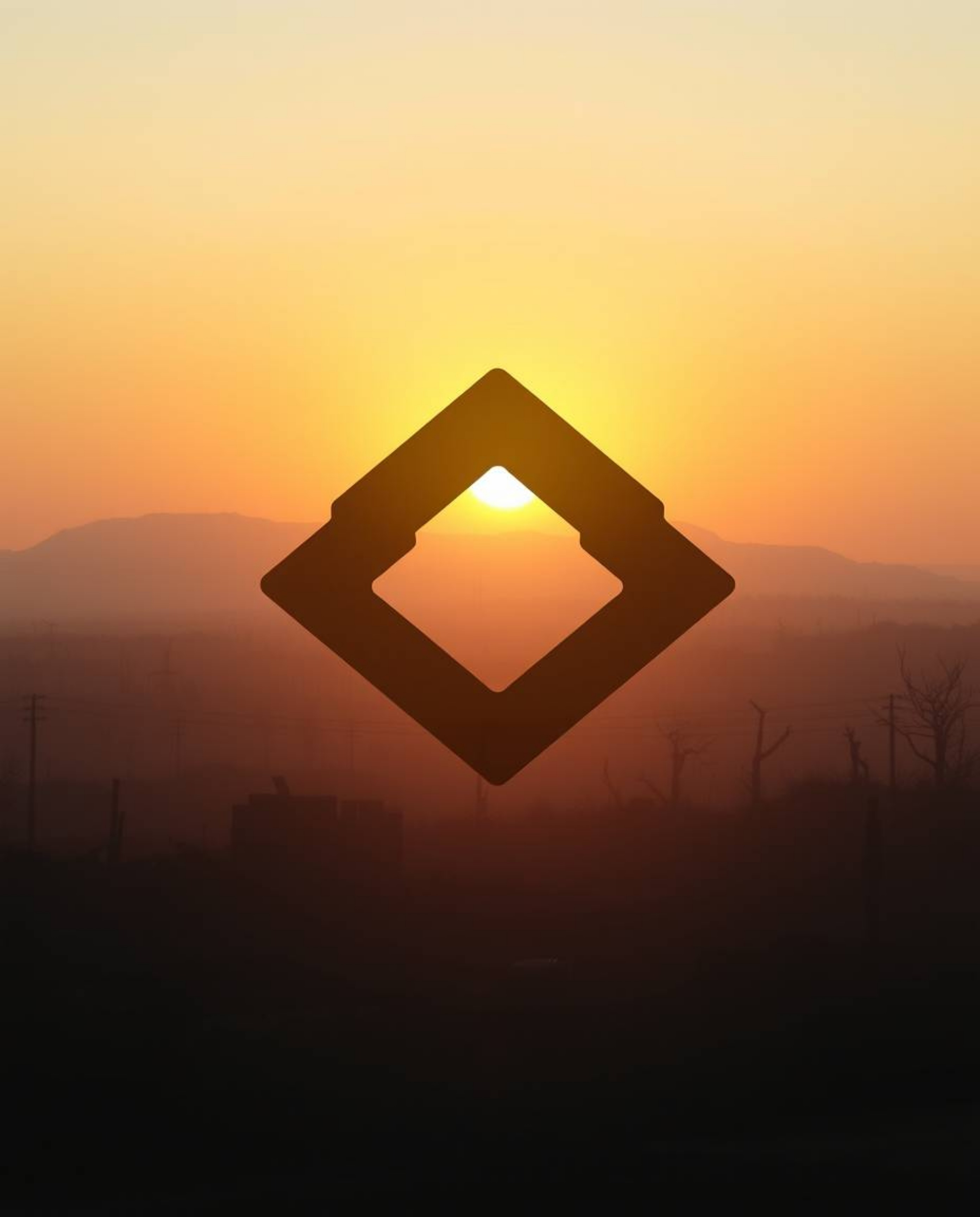 A captivating image depicting a soft, dreamy sunrise over a war-torn landscape.  The scene is enhanced by a geometric logo-in