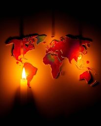 This image captures a creative abstract concept featuring distinct split warm candle lights that form a world map with bright