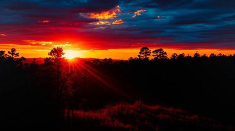 A captivating landscape photograph showcases a vibrant chiaroscuro effect, where sunset light dramatically filters through a 