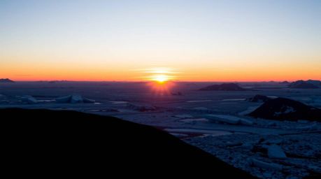 A captivating sunset unfolds over icy polar glaciers, presented in a distinct split composition that dramatically emphasizes 