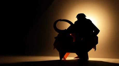 Experience a dramatic fusion of prehistoric cooking and intricate paper art. Imagine a caveman silhouetted against a light so
