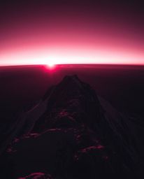Experience a surreal and dramatic vision of a sunset from a high alpine peak with this high-contrast, low-key image. Rendered