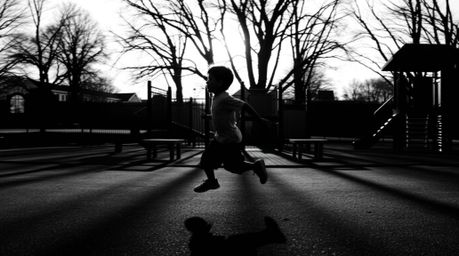 A dramatic slow-motion run through a playground captured in classic black and white photography featuring a silhouetted figur