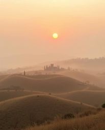 Dreamy sunset over misty Tuscan hills in soft, natural earth tones. Hazy, soft light, browns, beiges, and muted colors create