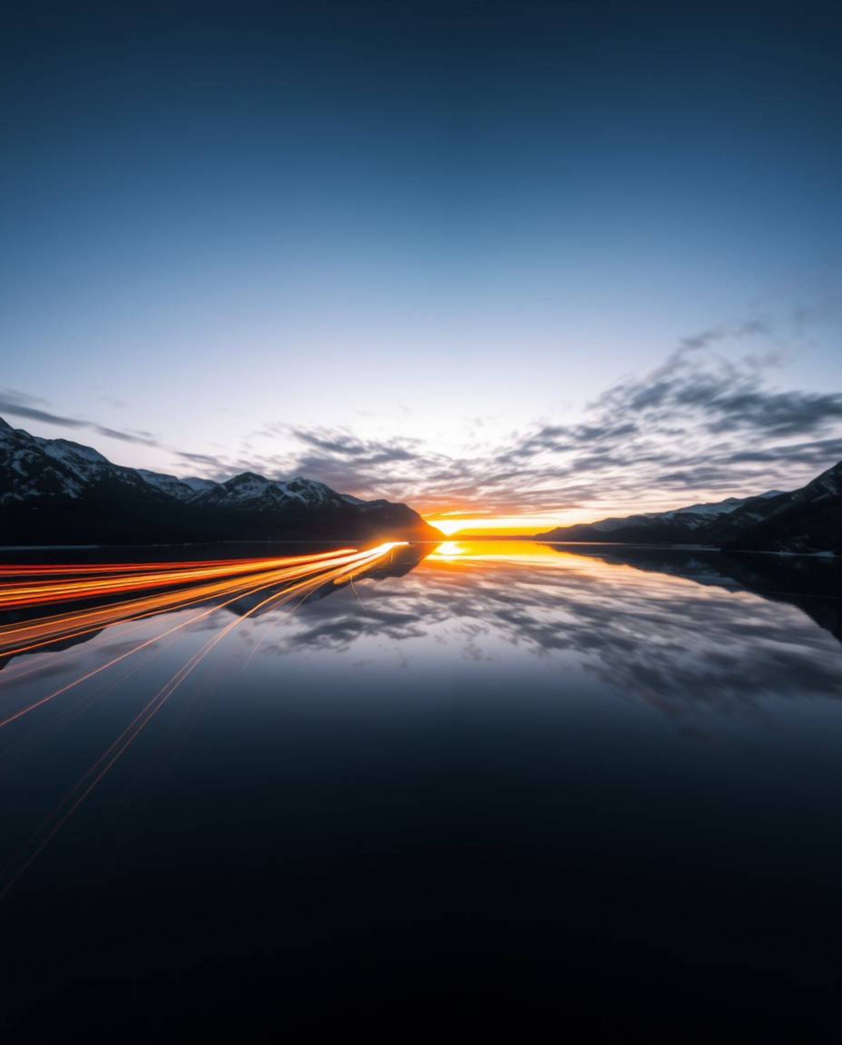A stunning long exposure photograph capturing the beautiful motion of light trails from a sunset as they reflect in a glassy
