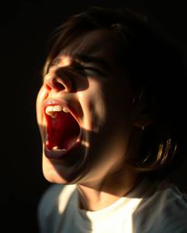 A captivating image depicting a person screaming amidst a world dissolving into pixels, illuminated by gentle, soft light.  T