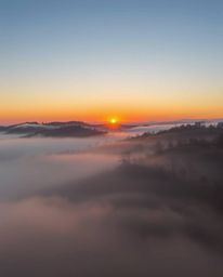 Sunset over misty rolling hills in Tuscany: low visibility, thick fog, thick foggy surroundings.