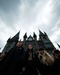 Capture the grandeur and enchantment of a magical school brimming with young wizards. This scene utilizes a dramatic low-angl