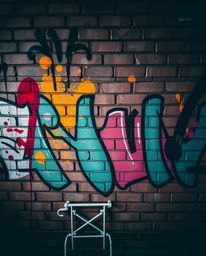 A captivating professional fine art photograph showcases vibrant graffiti-style splashes on a textured brick wall.  The image