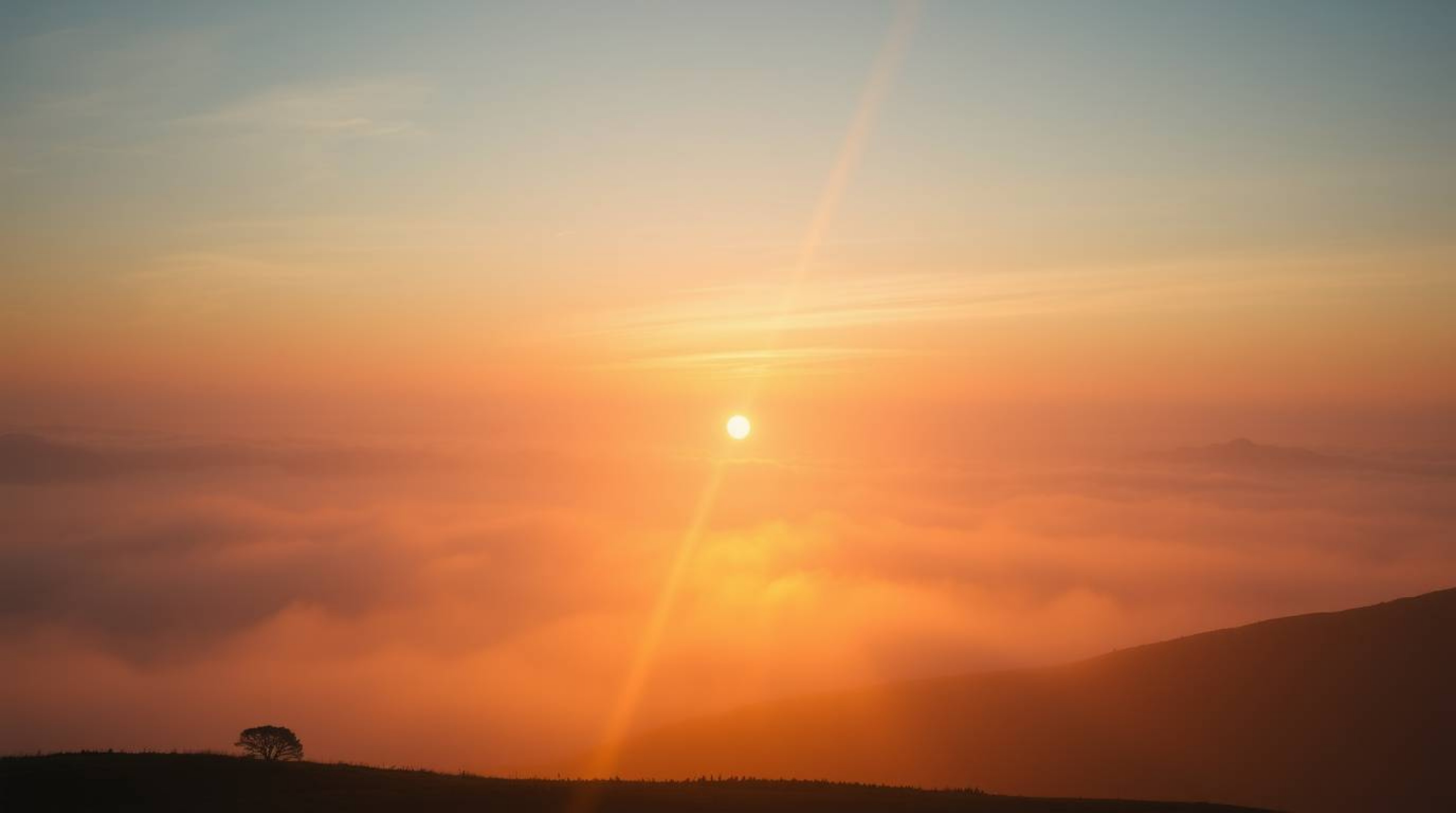 A breathtaking high-resolution stock photo depicting an epic scene of fog-covered hills bathed in the golden light of a drama