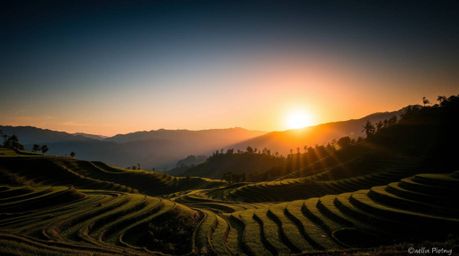 Experience the breathtaking beauty of a mountain sunset over cascading rice terraces, dramatically illuminated with high cont