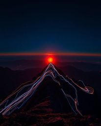 This is a creative light art piece that captures the essence of a sunset viewed from a high alpine peak. It employs artistic 