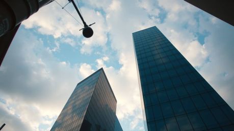 A captivating street photograph taken from a low angle presents a modern glass building seemingly dissolving into a soft, clo