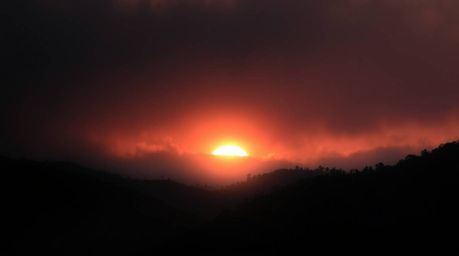 Experience the breathtaking beauty of fog-covered hills bathed in the warm glow of a breaking sunset. This dramatic landscape