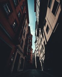 Explore a dramatic, surreal street scene captured from a low angle perspective, featuring buildings that appear to fold and t