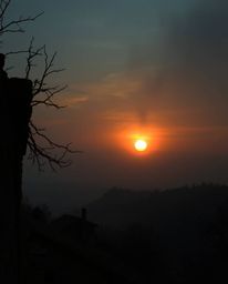 High-resolution stock photo: Eerie, creepy sunset over misty Tuscan hills. Dark tones, unsettling details. Commercial, profes