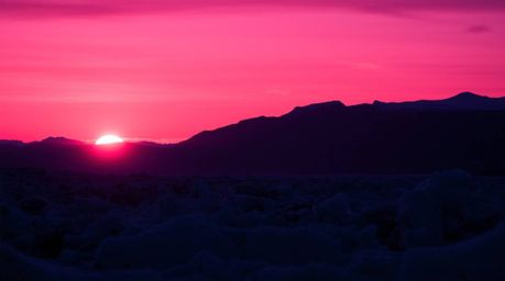 Experience the breathtaking beauty of a sunset over icy polar glaciers.  This captivating image showcases deep ultraviolet hu