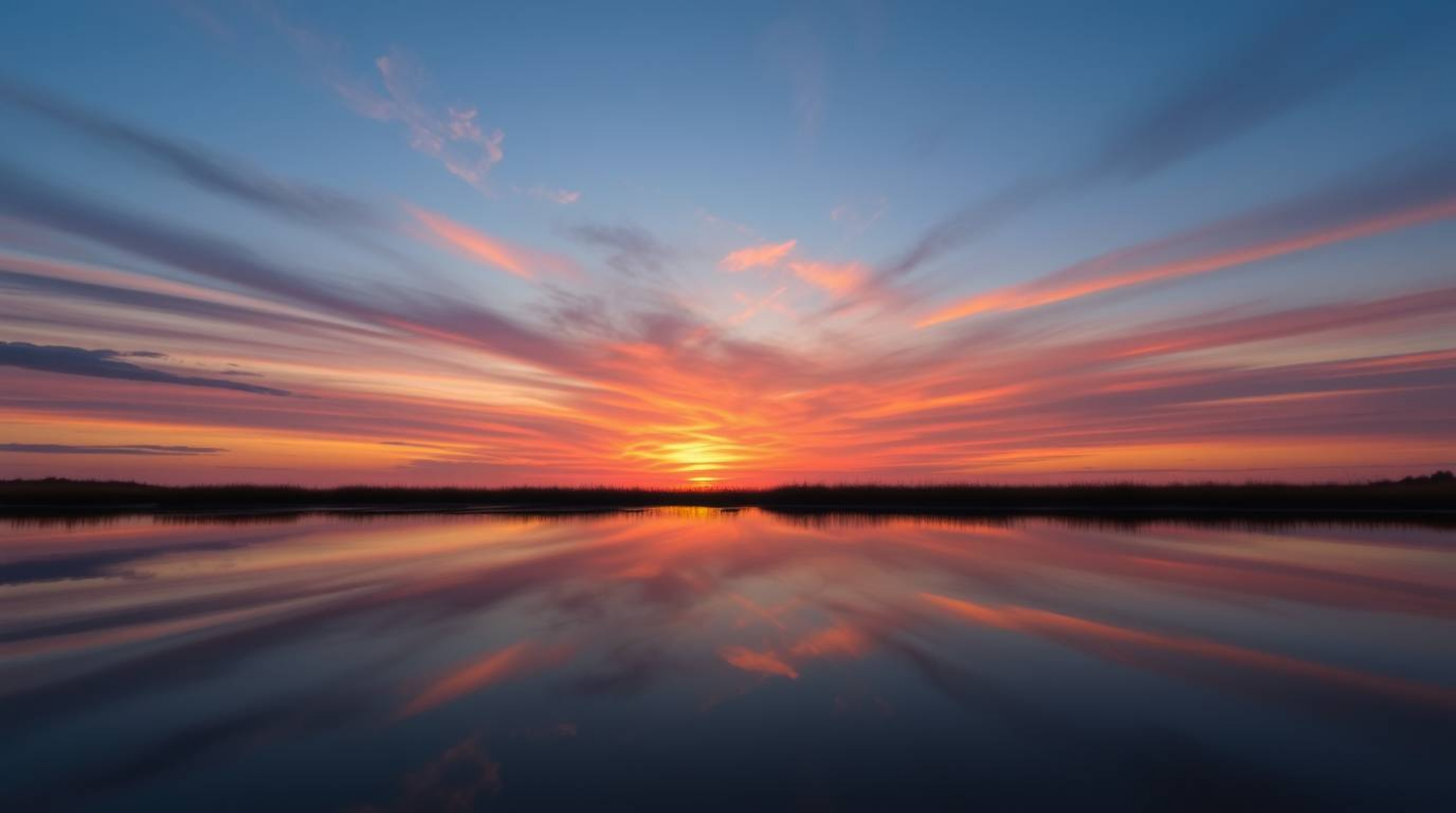 Capture the serene beauty of a colorful sunset mirrored in the tranquil waters of a calm pond. This image evokes a sense of f