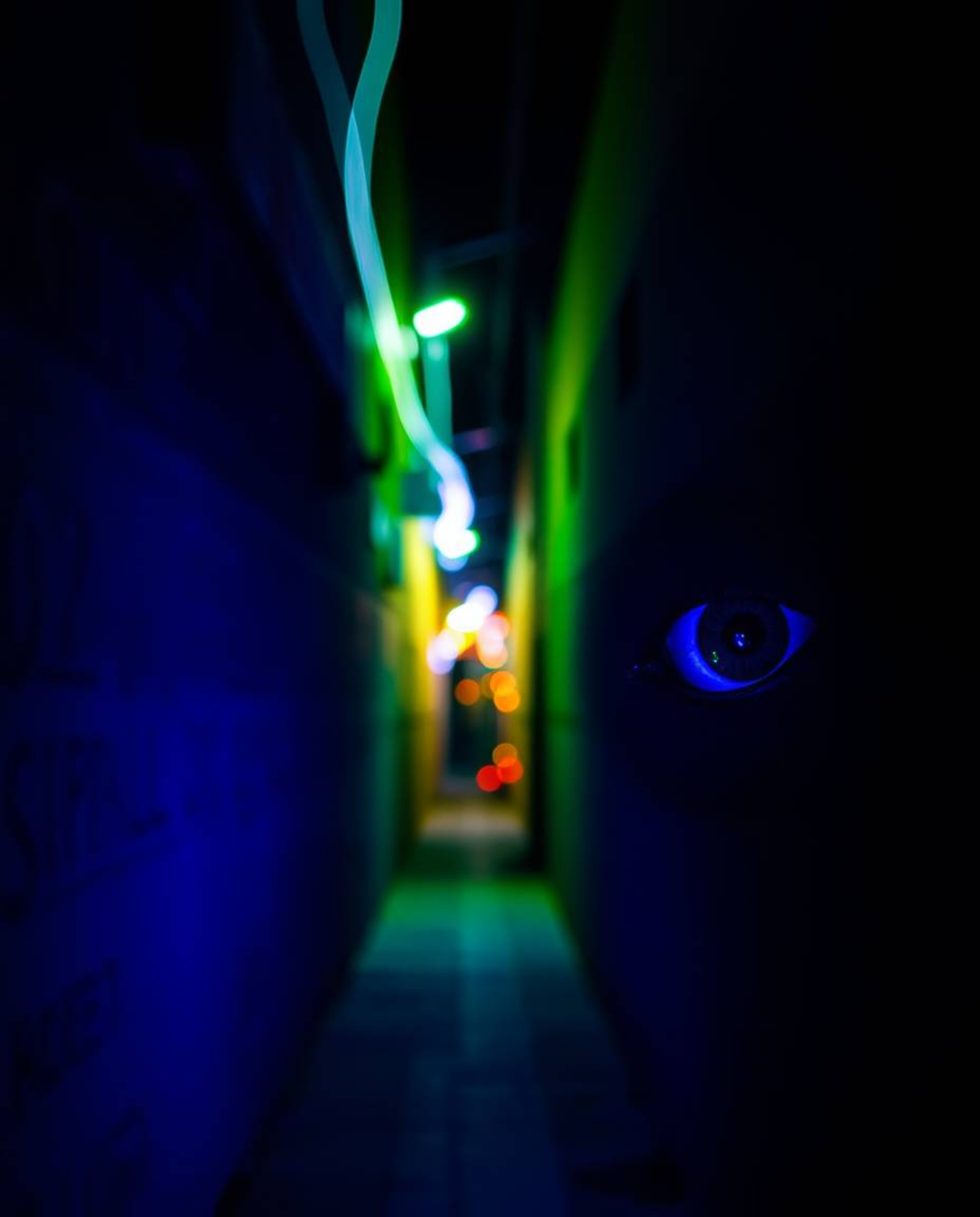 A mesmerizing long-exposure photograph captures the intensity of eyes watching from the shadows of a nighttime alley. Bathed 
