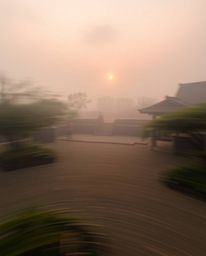 Dynamic motion blur depicting a foggy Zen garden at sunset, low visibility, blurred lines, action poses suggested.