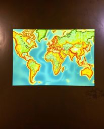 A captivating map projection illuminates an old study, featuring a cast bronze surface with a vibrant display of complementar