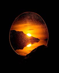 A cast bronze sculpture depicting a glassy fjord reflecting a sunset. This piece is defined by its high contrast and low-key 