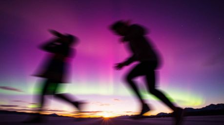 Experience the breathtaking beauty of a vibrant sunset sky, dramatically enhanced by the ethereal glow of the Northern Lights
