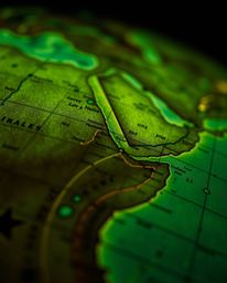 Explore the intricate details of a glowing map projection in an aged study setting, captured through an extreme macro close-u