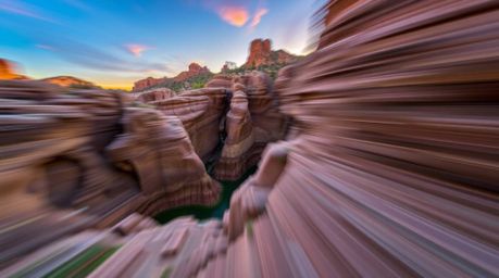 Experience the breathtaking beauty of a rocky canyon bathed in the warm glow of a sunset. This captivating scene features dyn