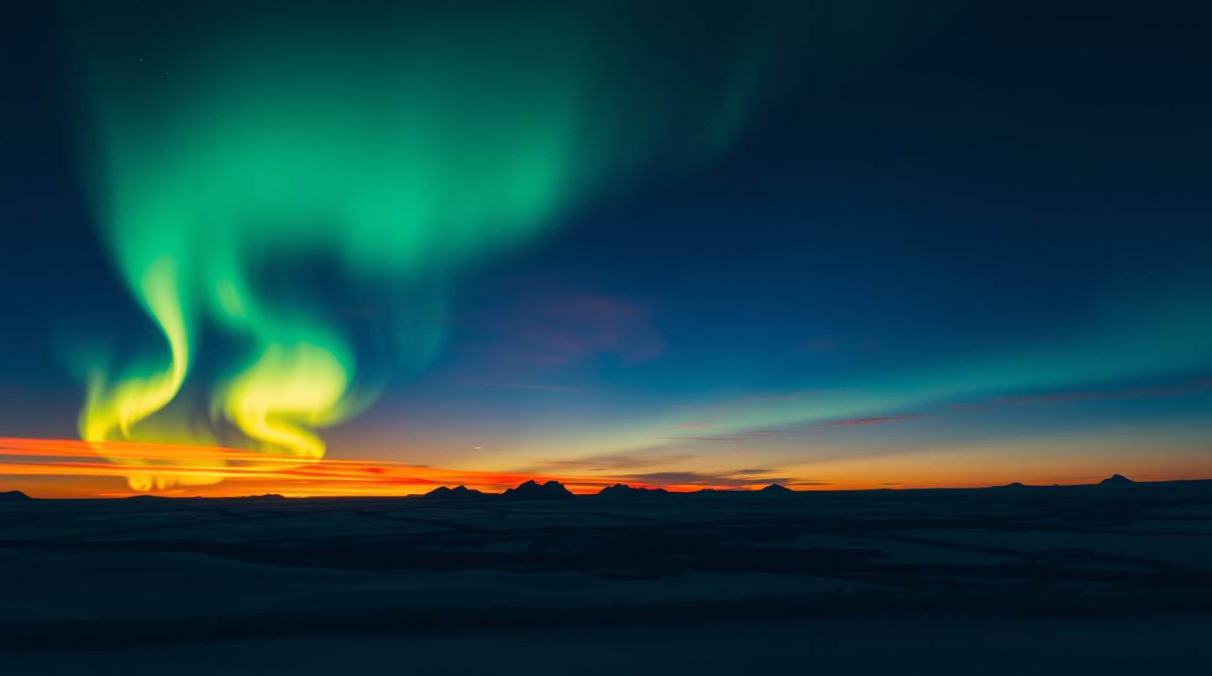 Witness the breathtaking spectacle of the Northern Lights emerging over a vibrant sunset sky. This captivating image showcase