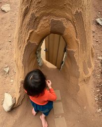 A captivating image depicts a child's wondrous discovery of a hidden magical portal nestled within a serene earth-toned backy