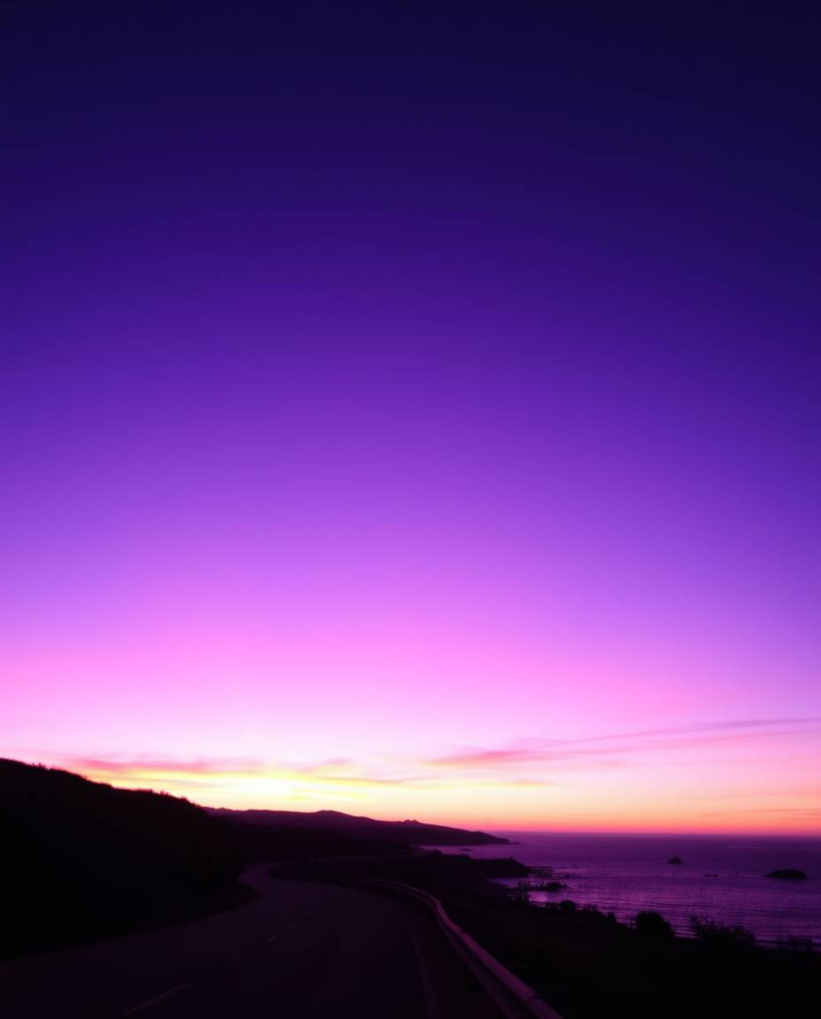 Experience a mystic and enchanting environment where a sunset sky, rich with deep ultraviolet hues and vivid purples, hangs o