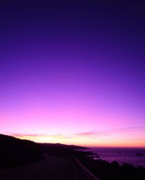 Experience a mystic and enchanting environment where a sunset sky, rich with deep ultraviolet hues and vivid purples, hangs o