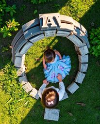 A captivating overhead view captures a child's enchanting discovery of a magical portal shimmering with iridescent reflection