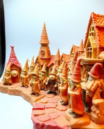 This sculptural clay art piece depicts a magical school brimming with young wizards. The warm color palette, dominated by red