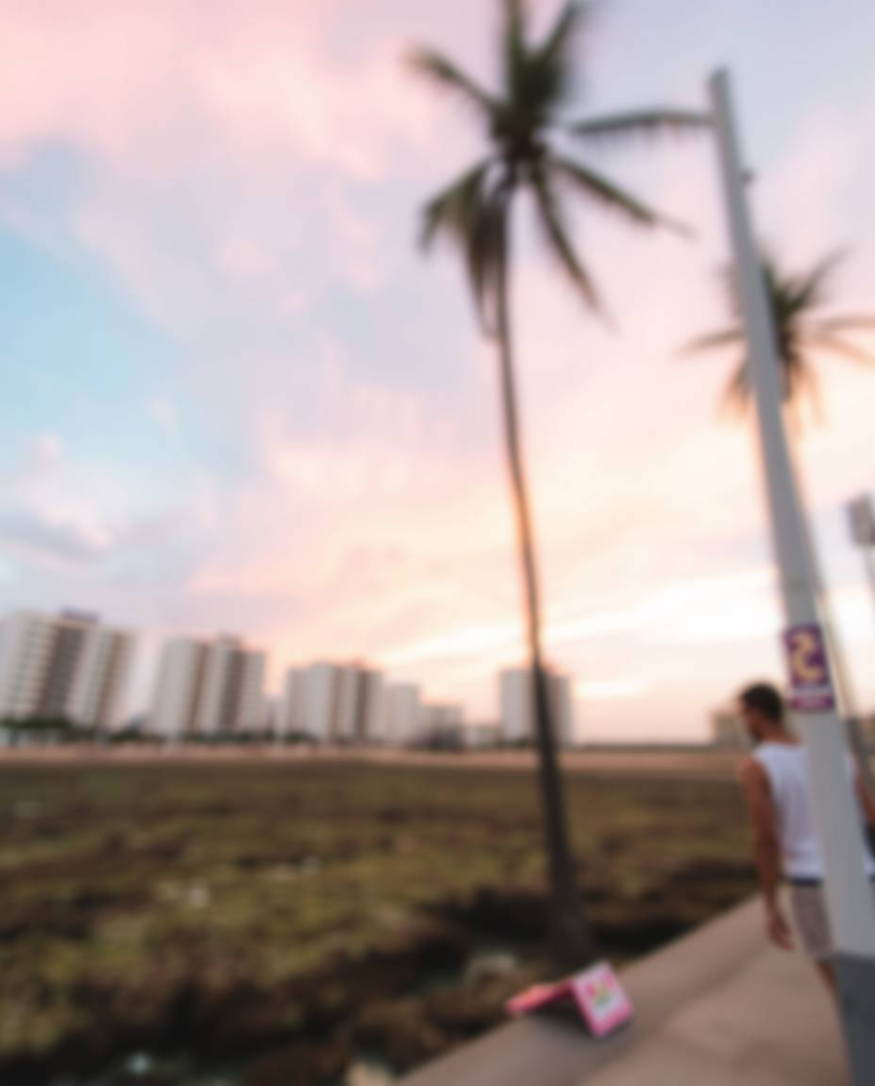 A candid street photography style captures a spontaneous moment, featuring a sharply focused image of a colorful sky over a c
