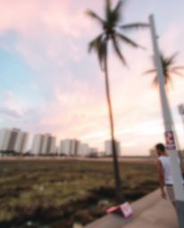 A candid street photography style captures a spontaneous moment, featuring a sharply focused image of a colorful sky over a c