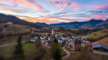 A captivating photograph showcasing a cozy village nestled in a serene valley, set against a vibrant and colorful sky. The im